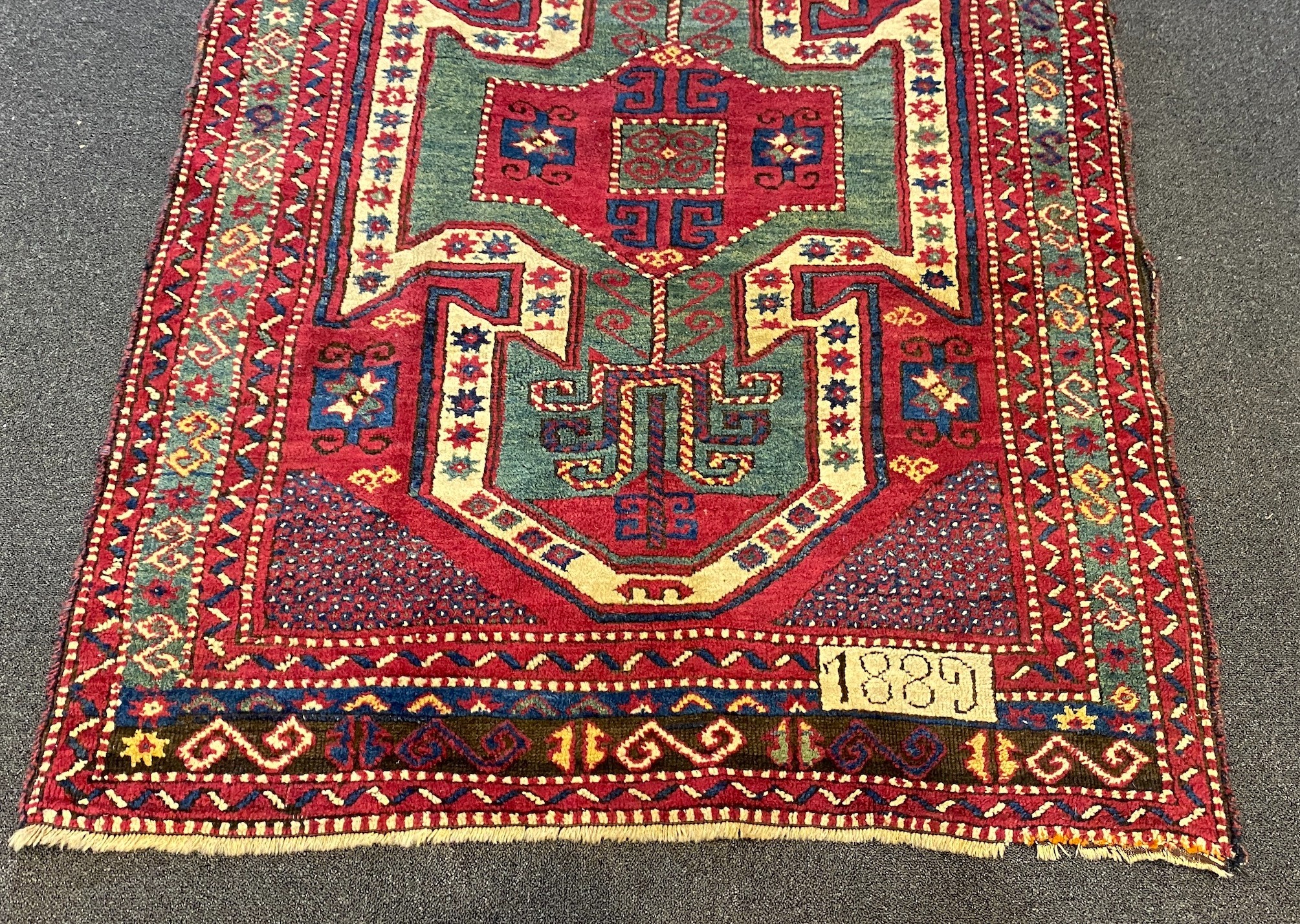 An antique Kazak red ground rug, 280 x 120cm